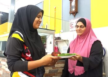 RAMJAN Bebe Sheikh Mohd. Khan (kanan) melayani seorang pelanggannya di Restoran Iqa Corner Nasi Wanggey Malim Nawar di Kampar. – UTUSAN/MEGAT LUTFI MEGAT RAHIM