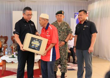 ADLY Zahari (kiri) menyampaikan sumbangan bakul makan kepada veteran tentera semasa Program Veteran Desa Madani Peringkat Jajahan Tanah Merah di Sekolah Kebangsaan (SK) Bechah Laut, Tanah Merah, Kelantan hari ini-UTUSAN/KAMARUL BISMI KAMARUZAMAN.