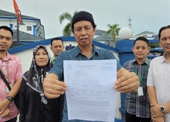 TUNKU Mohammed Nazarin Tunku Yusoff (tengah) menunjukkan laporan polis yang dibuat di IPD Kota Bharu, Pengkalan Chepa, Kota Bharu, Kelantan, hari ini. - UTUSAN/MUSTAQIM MOHAMED