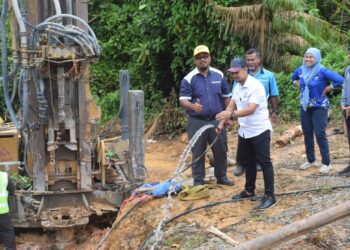 HARIS SALEH Hamzah (depan) melakukan gimik pancutan air pertama daripada projek telaga tiub di Kampung Batu  Balak Kuala Tembeling di Jerantut, Pahang. - UTUSAN/SALEHUDIN MAT RASAD