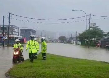 ANGGOTA polis memantau keadaan banjir di Jalan Kolombong, Kota Kinabalu hari ini.