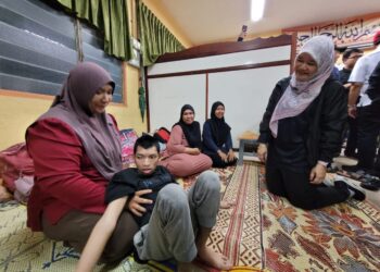 FADHLINA Sidek (kanan) menyantuni beberapa keluarga mangsa banjir di PPS SK Demit, Kubang Kerian, Kota Bharu, Kelantan hari ini. - UTUSAN/MUSTAQIM MOHAMED