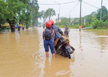 PASANGAN suami isteri menunggang motosikal meredah banjir dekat Persiaran Hamzah Alang, Meru, Klang, Selangor, semalam.
