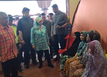 AL-SULTAN Abdullah Ri'ayatuddin Al-Mustafa Billah Shah (kiri) bersama Tunku Azizah Aminah Maimunah Iskandariah berangkat bercemar duli menyampaikan bantuan kepada mangsa banjir di Pusat Pemindahan Sementara (PPS) Dewan Kampung Lechar di Raub, Pahang.