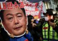 SEORANG penunjuk perasaan memegang sepanduk mengecam Yoon Suk Yeol ketika protes menggesa penggulingannya di Seoul.-AFP