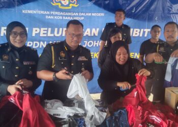 LILIS  SASLINDA Pornomo (tengah) menggunting pakaian tiruan pada program Pelupusan Ekshibit Perdana di Kompleks Penyimpanan Ekshibit Senai, Kulai.