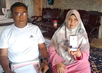 ZURIAH Mohd. Noor menunjukkan akaun TikToknya, ‘Zuriah Nur’ ditemani suami, Mohd. Azli Sulaima di Felda Kota Gelanggi Dua di Jerantut, Pahang semalam. – UTUSAN/HARIS FADILAH AHMAD