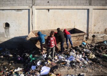 Kanak-kanak Palestin mencari sisa-sisa makanan di dalam tong sampah di Deir el-Balah, tengah Gaza semalam. -AFP