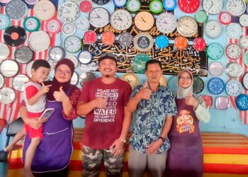 ANUAR Awang (dua dari kanan) bersama sebahagian daripada 200 koleksi jam dindingnya di restoran milik keluarganya di Chenderong Balai, Teluk Intan, Perak semalam.