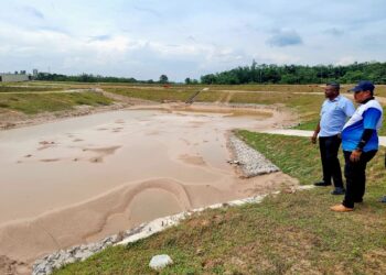 J. ARUL Kumar (kiri) menunjukkan salah satu kolam tadahan Bandar Hamilton di Nilai yang perlu didalamkan lagi bagi mengelakkan kejadian banjir di Pekan Nilai, Negeri Sembilan semalam.