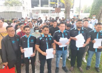 HISHAMUDDIN Hashim (tiga dari kiri) bersama para pelabur membuat laporan di Bank Negara Malaysia di George Town, Pulau Pinang, semalam.