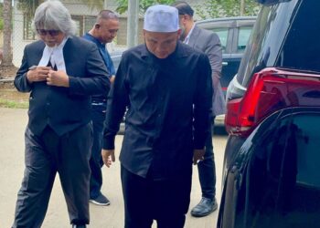 EBIT Lew bersama peguam Ram Singh semasa tiba di Mahkamah Majistret Tenom, Sabah semalam.