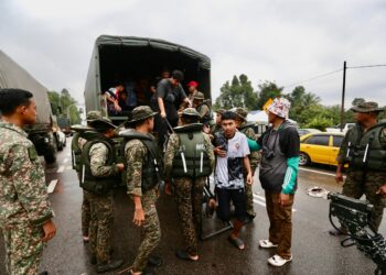 ANGGOTA ATM membantu memindahkan pelajar SPM yang terjejas dengan banjir untuk menduduki ujian lisan esok di Pasir Mas, Kelantan. - UTUSAN/KAMARUL BISMI KAMARUZAMAN.