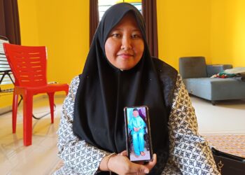 ROSLINA Mohd. Mahat menunjukkan gambar bapanya, Mohd. Mahat Said yang hilang sejak 16 Disember lalu ketika ditemui di rumahnya di Kampung Air Melintang, Kota, Rembau hari ini.-UTUSAN/NOR AINNA HAMZAH.