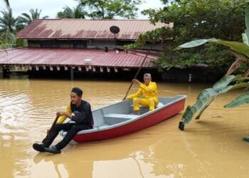 JAMAL Batong mendayung bot bersama-sama seorang penduduk meredah banjir di Kampung Bukit Tunggal, Segamat.