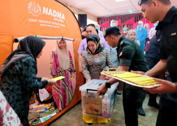 TENGKU Anis Tengku Abdul Hamid (tengah) berkenan menyampaikan sumbangan tunai dan bakul makanan kepada mangsa-mangsa banjir di PPS SK Padang Pohon Tanjung, Tumpat, Kelantan. - UTUSAN/MUSTAQIM MOHAMED