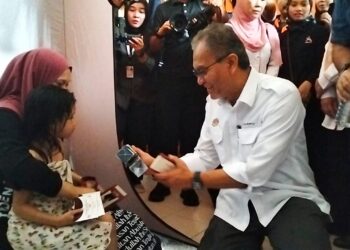 Dzulkefly Ahmad (kanan) menyampaikan sumbangan kepada mangsa banjir di Pusat Pemindahan Banjir (PPS) Maktab Rendah Sains Mara (MRSM) Tumpat di Pengkalan Kubor, Kelantan. - UTUSAN/ROHANA ISMAIL