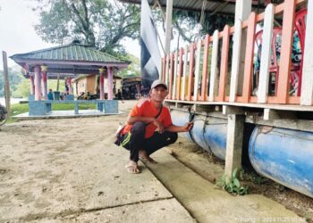 NORHIDAYAT Nahari menunjukkan tong dipasang di bawah lantai kedai kopi di Kampung Bantal, Ulu Tembeling di Jerantut, Pahang. – UTUSAN/HARIS FADILAH AHMAD
