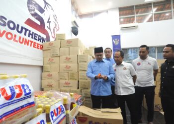 HASRIN KAMAL Hashim (kiri) melihat barang makanan yang akan dihantar kepada mangsa banjir di negeri ini di Pejabat Penolong Setiausaha Kerajaan Johor (Belia, Sukan & Sukarelawan) di Iskandar Puteri.