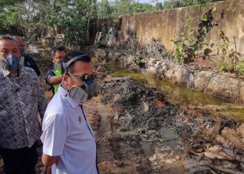 NIK Nazmi Nik Ahmad dan Aminuddin ketika meninjau lokasi pelupusan sisa terjadual secara haram di Bukit Pelandok, Port Dickson hari ini. - UTUSAN/MOHD. SHAHJEHAN MAAMIN