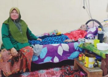 NORLIDA Abd. Talib @ Abd. Razak menguruskan Abdul Rahman Aripin yang diserang angin ahmar di Felda Kota Gelanggi Empat, Jerantut, Pahang. - UTUSAN/HARIS FADILAH AHMAD
