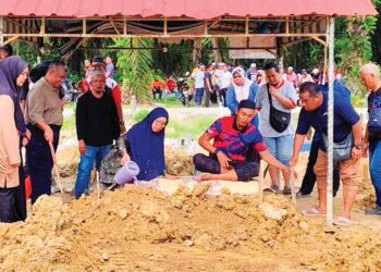 AHLI keluarga menyiram air di pusara Koperal Muhammad Taufik Sayutin di Tanah Perkuburan Islam Felcra Changkat Lada di Kampung Gajah, Pasir Salak, Perak. - UTUSAN