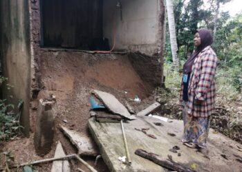 SALIDA Rahman melihat bilik air dan tandas rumahnya yang runtuh akibat dihentam arus deras banjir, baru-baru ini di Kampung Lubuk Periuk, Hulu Terengganu.  - UTUSAN/ NOOR HAYATI MAMAT