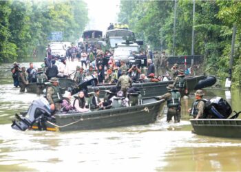 ANGGOTA tentera membantu memindahkan calon-calon SPM yang terkandas di Rantau Panjang, Kelantan. – UTUSAN/KAMARUL BISMI KAMARUZAMAN