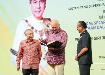 SULTAN Nazrin Shah berkenan melihat buku sejarah perjuangan dan pengorbanan PDRM dalam mengekalkan keamanan negara selepas pelancarannya, di Kuala Lumpur, semalam. Turut hadir, Razaruddin Husain (kanan). – UTUSAN/FARIZ RUSADIO