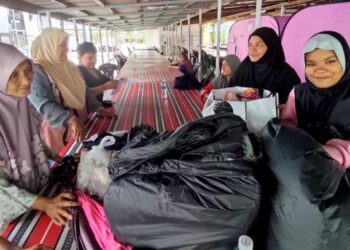 WAN Nisah Wan Mahmud (kiri) bersama jirannya di Pusat Pemindahan Sementara (PPS) di Masjid Kampung La, Besut, Terengganu. - UTUSAN/WAN ZURATIKAH IFFAH WAN ZULKIFLI