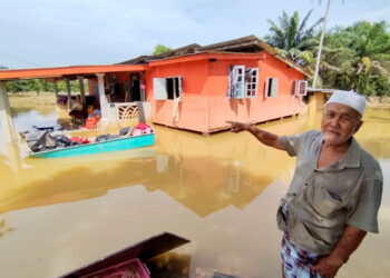 ZAKARIA Ismail menunjukkan keadaan rumahnya yang masih ditenggelami air banjir di Kampung Nyatoh, Setiu, Terengganu. - UTUSAN / WAN ZURATIKAH IFFAH WAN ZULKIFLI