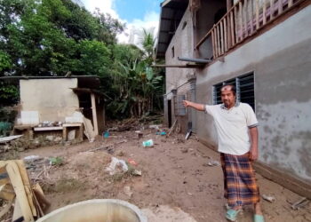 RAJA Kamarudin Raja Mohamed menunjukkan sisa bilik mandi berhampiran kediaman baharunya selepas rumah lamanya musnah dihanyutkan arus banjir di Kampung La, Besut, Terengganu, dua tahun lalu. -UTUSAN