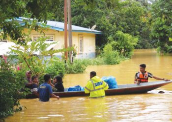 ANGGOTA Balai Polis Bertam membantu mangsa banjir yang terjejas di Kampung Limau Kasturi, Gua Musang, Kelantan. – UTUSAN/AIMUNI TUAN LAH