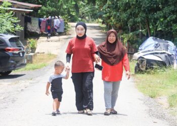SITI Norelyana Kamarulzaman (tengah) berjalan sambil ditemani ibu dan anak saudaranya sewaktu ditemui di Kampung Paloh 3, Gua Musang, Kelantan. – UTUSAN/KAMARUL BISMI KAMARUZAMAN