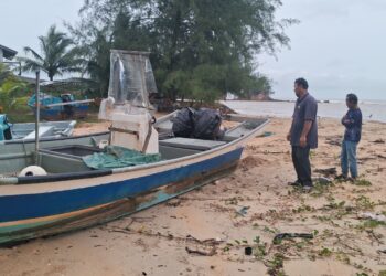 KEMAMAN 11 DISEMBER 2024 - BEBERAPA nelayan memeriksa keadaan salah sebuah bot yang diselamatkan selepas hanyut dibawa arus di Pantai Kemasik, Kemaman, Terengganu. - UTUSAN/NIK NUR IZZATUL HAZWANI NIK ADNAN