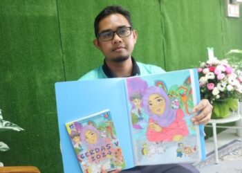 MOHAMAD Yazid menunjukkan buku bertajuk CERDAS V hasil karya kreatif murid Sekolah Kebangsaan Ulu Jempol, Maran Pahang.