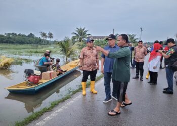 MOHAMAD Sabu (dua dari kiri) mendengar penjelasan daripada pesawah mengenai tanaman padi yang terjejas banjir sewaktu lawatannya ke Bendang Padi Pangkal Kala, Pasir Mas, Kelantan hari ini. - UTUSAN/MUSTAQIM MOHAMED