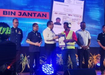 ANTHONY Loke Siew Fook menyerahkan lesen B2 kepada salah seorang penerima pada Majlis Perasmian Penutup Program MyLesen Peringkat Negeri Sembilan di Dewan Besar Kuala Klawang, Jelebu hari ini.