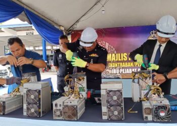 MASLAN Udin (tiga dari kanan) ditemani Uthman Abd. Ghani (dua dari kanan) menyempurnakan simbolik pelupusan barang kes di pekarangan Trafik IPD, Port Dickson, hari ini. - UTUSAN/NOR AINNA HAMZAH