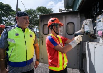 DARLVEEN (kiri) ketika operasi memotong bekalan elektrik di premis sekitar Jalan Ampang, hari ini. Gambar: M. FIRDAUS M. JOHARI