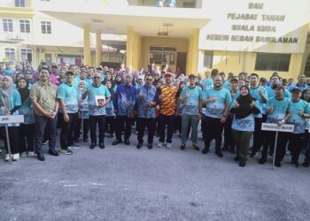 ADNAN Mat (tengah) bergambar bersama kakitangan awam sempena Perhimpunan Bulanan Kompleks Pentadbiran Daerah Kuala Muda di Sungai Petani.