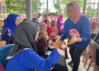 NOORJAYA Najwa Najib (kanan) beramah mesra dengan mangsa banjir di Kampung Kandis, Pasir Puteh, Kelantan hari ini. UTUSAN/TOREK SULONG