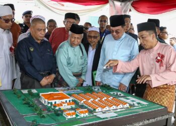 ANWAR Ibrahim melihat pelan pembinaan Pusat Pengajian At-Taiyibin di Chemor dekat Ipoh hari ini. - UTUSAN/MUHAMAD NAZREEN SYAH MUSTHAFA