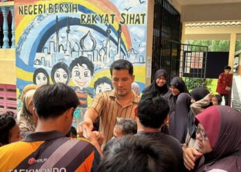 ALIFF Syukri menghulurkan sumbangan wang tunai kepada mangsa banjir di Sekolah Kebangsaan Kompleks Gong Badak, Kuala Nerus, Terengganu. - UTUSAN KAMALIZA KAMARUDDIN