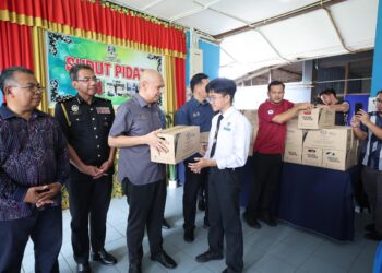 ARMIZAN Mohd. Ali (tiga, kiri) menyampaikan sumbangan makanan kepada salah seorang calon SPM di SMK Ayer Puteh, Kemaman, Terengganu, hari ini. - UTUSAN/PUQTRA HAIRRY ROSLI