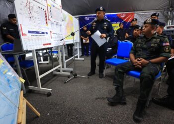 AYOB Khan Mydin Pitchay (duduk, kanan) diberikan taklimat oleh Mohd. Yusoff Mamat berkait situasi terkini banjir di Kelantan semasa melawat Balai Polis Repek, Pasir Mas, Kelantan-UTUSAN/YATIMIN ABDULLAH