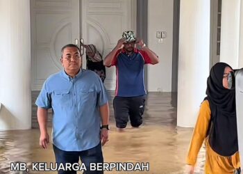 MUHAMMAD Sanusi Md Nor mengharung air untuk berpindah keluar dari kediaman rasminya yang dinaiki air di Seri Mentaloon, Alor Setar.