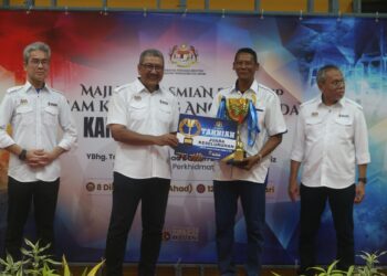 WAN Ahmad Dahlan Abdul Aziz (dua dari kiri) menyerahkan piala kepada Pengerusi MPKK Pulau Aman, Zulkplee Yusoff sempena Majlis Perasmian Penutup Program Kampung Angkat MADANI Jabatan Perkhidmatan Awan (JPA) di Kampung Pulau Aman, Pulau Pinang hari ini.