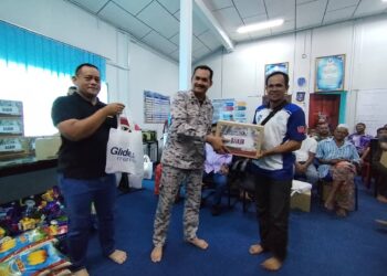 Khairulanuar Abd Majid (tengah) menyerahkan bantuan kepada keluarga komuniti maritim melalui Skuad Ihsan Madani KDN di Kuala Besut, Terengganu, hari ini.- Utusan /Wan Zuratikah Iffah Wan Zulkifli