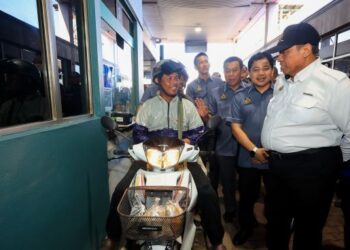 SHAMSUL Azri Abu Bakar (kanan) beramah mesra bersama penunggang motosikal warga Thailand yang memasuki sempadan Malaysia di Kompleks Imigresen, Kastam, Kuarantin dan Keselamatan (ICQS) Rantau Panjang, Kelantan, semalam. – UTUSAN/KAMARUL BISMI KAMARUZAMAN